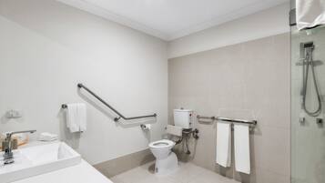 A modern bathroom with a white sink, toilet, and glass shower enclosure.