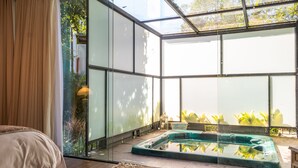A modern interior with a glass-enclosed swimming pool, a comfortable seating area, and a view of the outdoors. - Locanda Della Mimosa (Petrópolis)