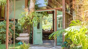 A wooden structure with a green door, a reception sign, and a sign for a restaurant. - Locanda Della Mimosa (Petrópolis)