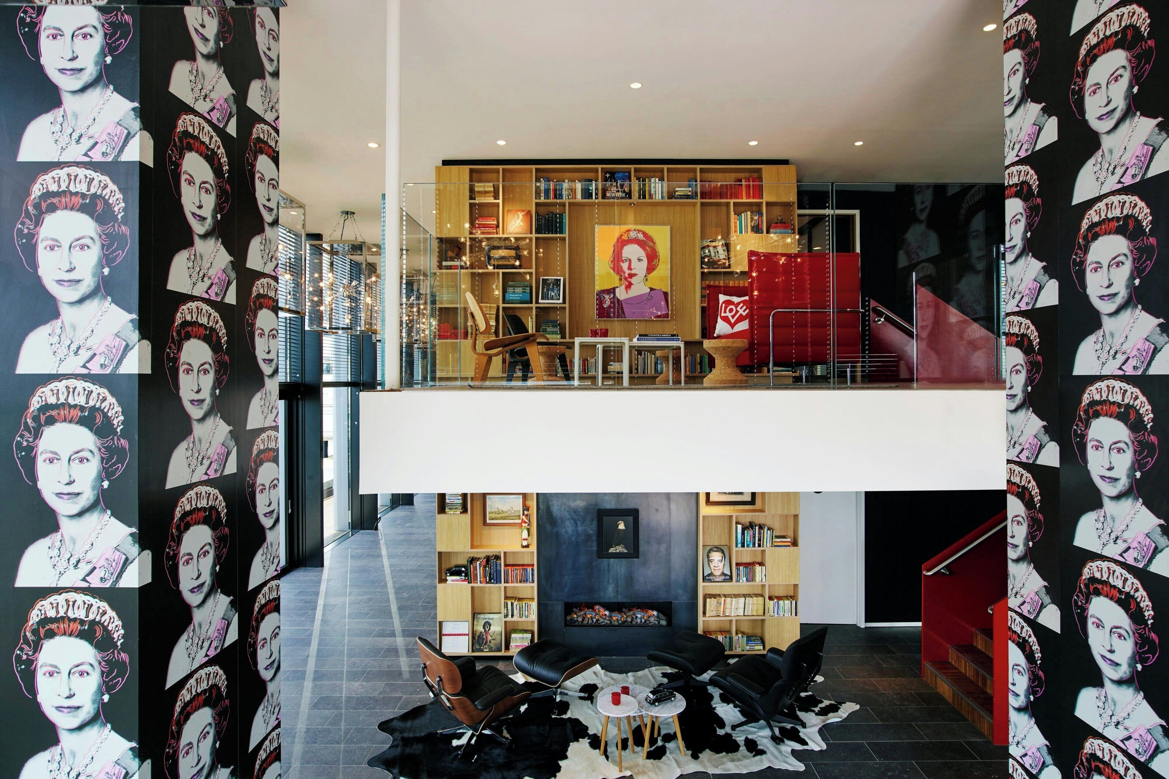A modern interior with a central seating area, bookshelves, and a staircase.