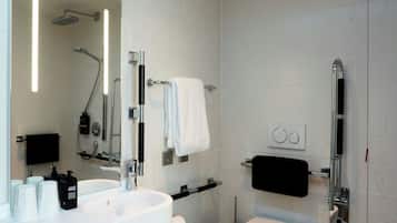 Ein modernes Badezimmer mit einem weißen Waschbecken, einer Toilette, einer Dusche und einem großen Spiegel.