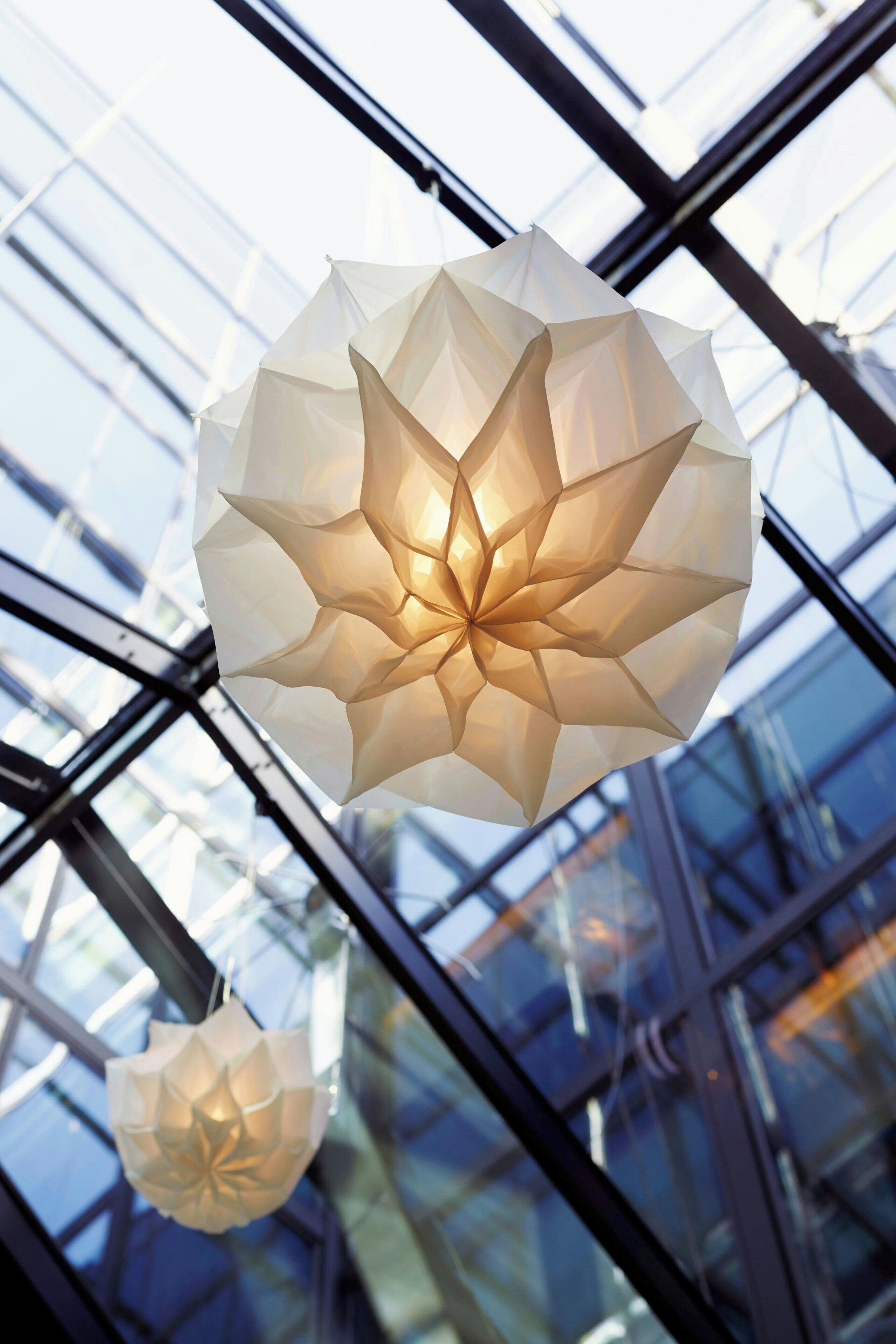 A modern interior with geometric glass panels and hanging paper lanterns.