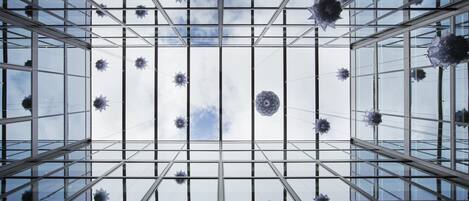 A modern glass ceiling with geometric patterns and hanging spherical decorations.