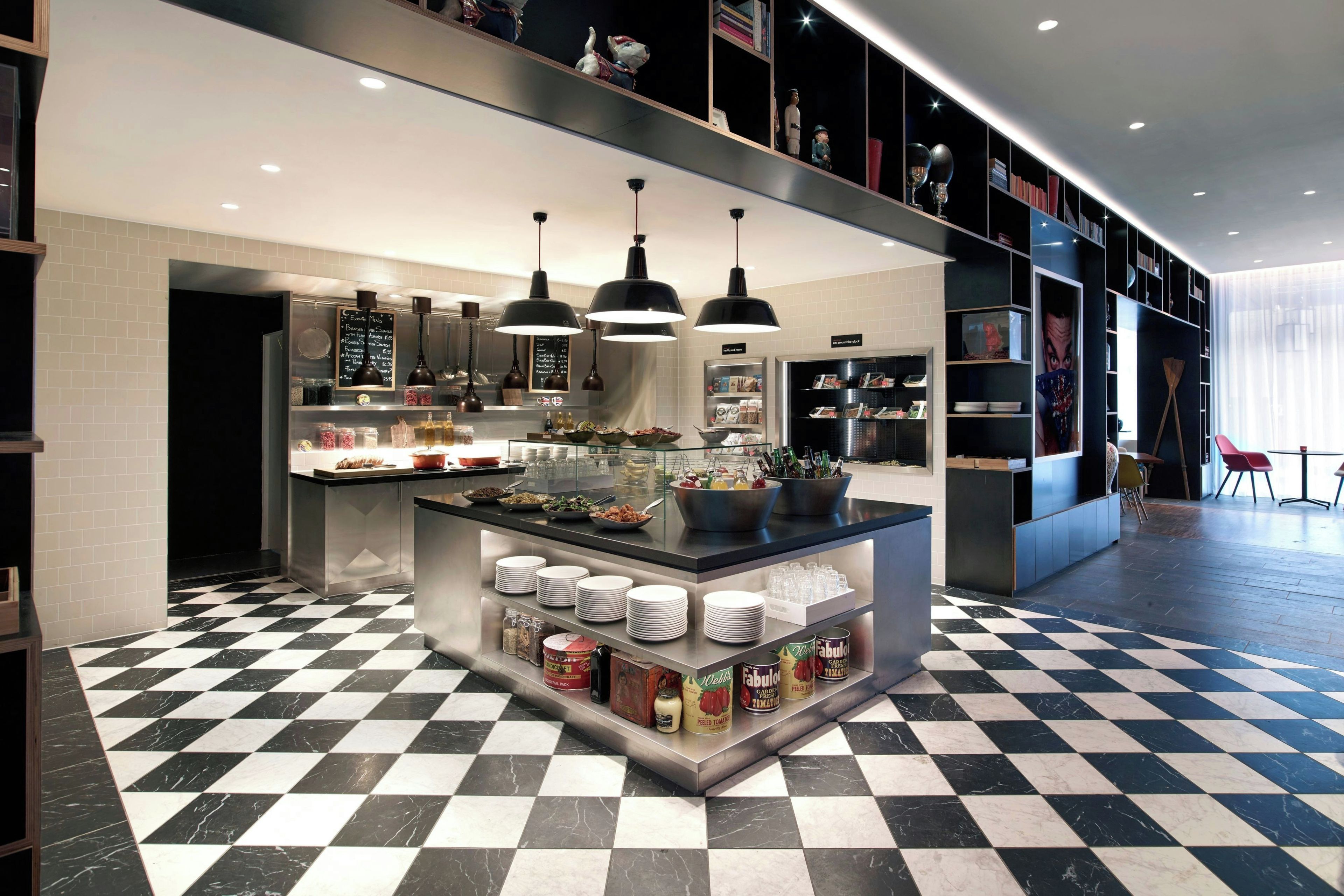 Una cocina moderna con una isla central, lámparas colgantes negras y piso a cuadros.
