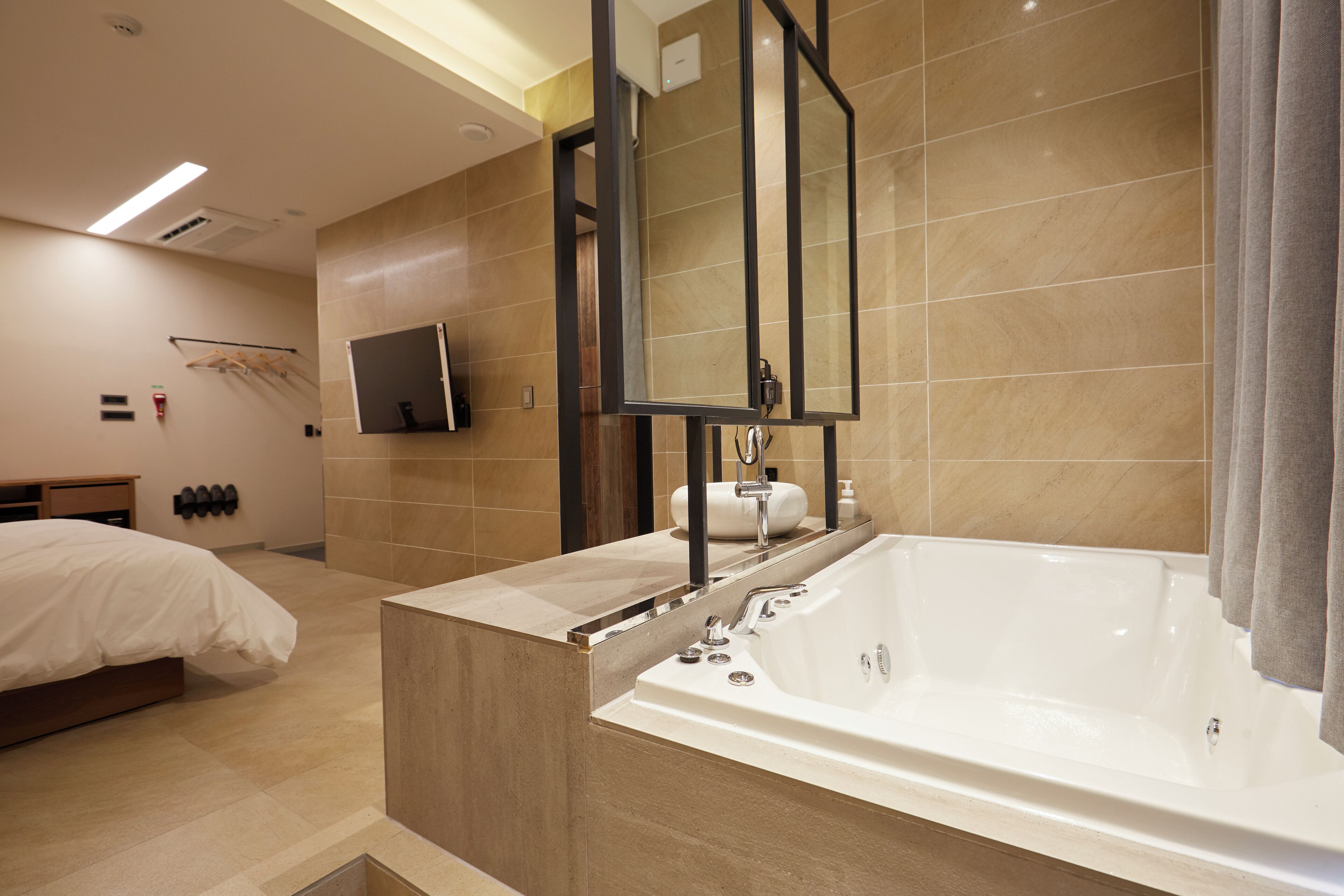Un baño moderno con una bañera grande, un tocador con espejo y una zona de ducha.