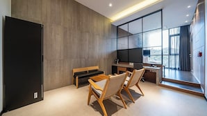 Ein modernes Zimmer mit großem Fenster, Schreibtisch, Stuhl und einer Bank.