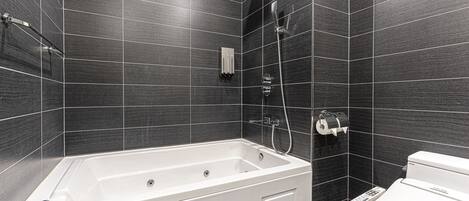 Une salle de bain moderne avec une baignoire sur pieds, des toilettes et une douche.