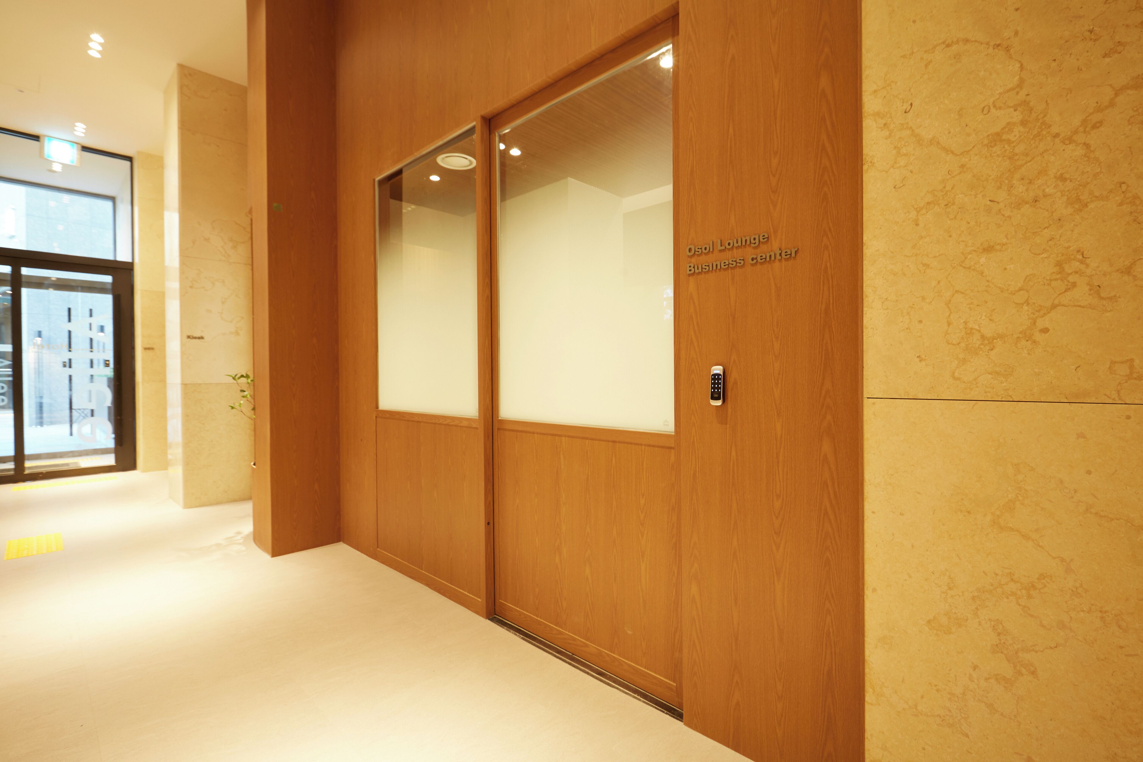 A hallway with a wooden door labeled "Osol Lounge Business Center."