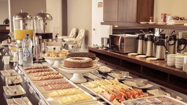 A buffet with various food items and beverages, including cakes, pastries, and a coffee station. - Hotel 10 Palmas (Palmas)