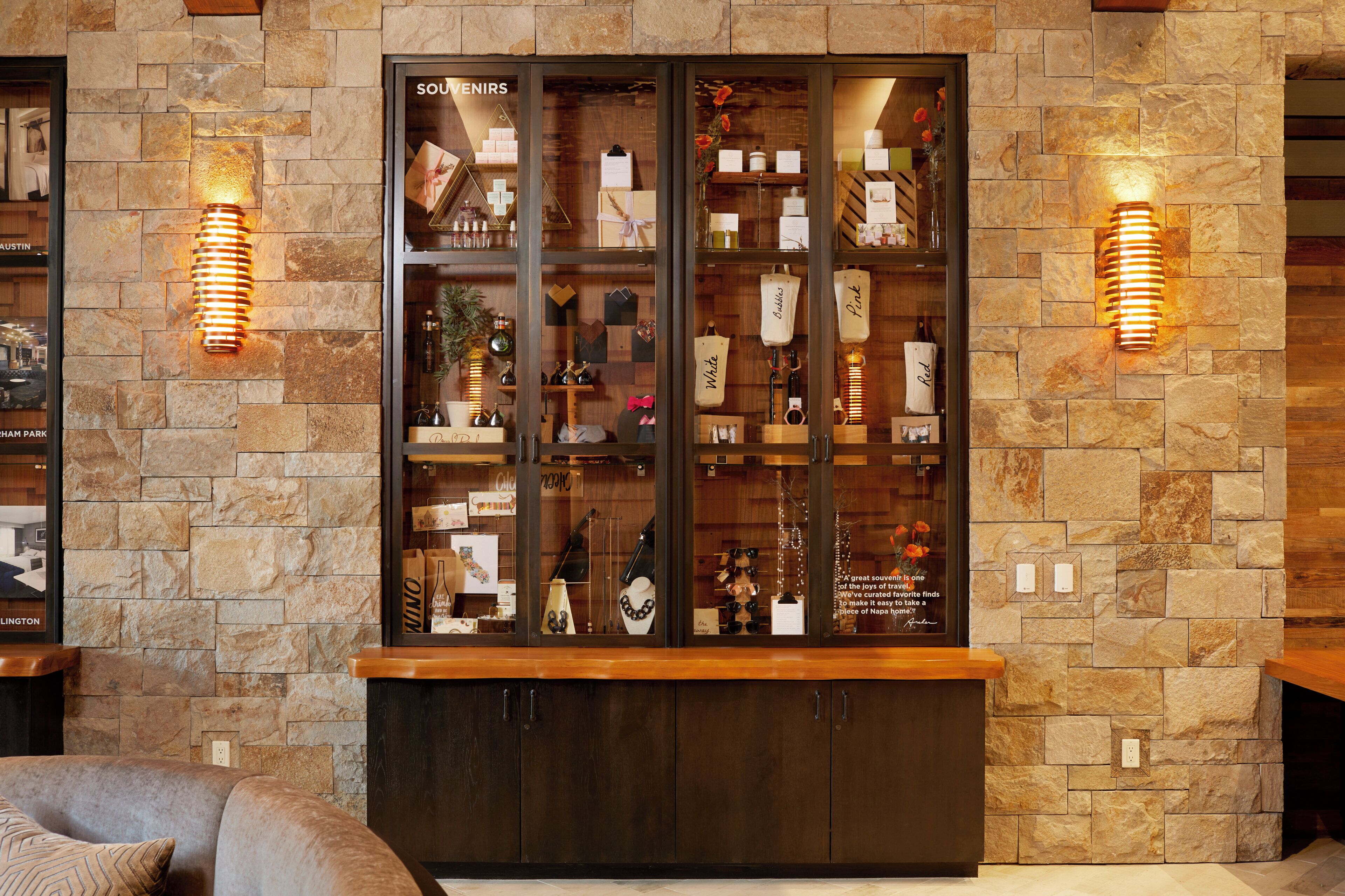 A stone wall with a glass display case containing various items.