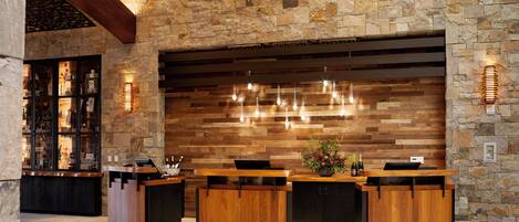 A reception area with a stone wall, wooden reception desk, and hanging lights.