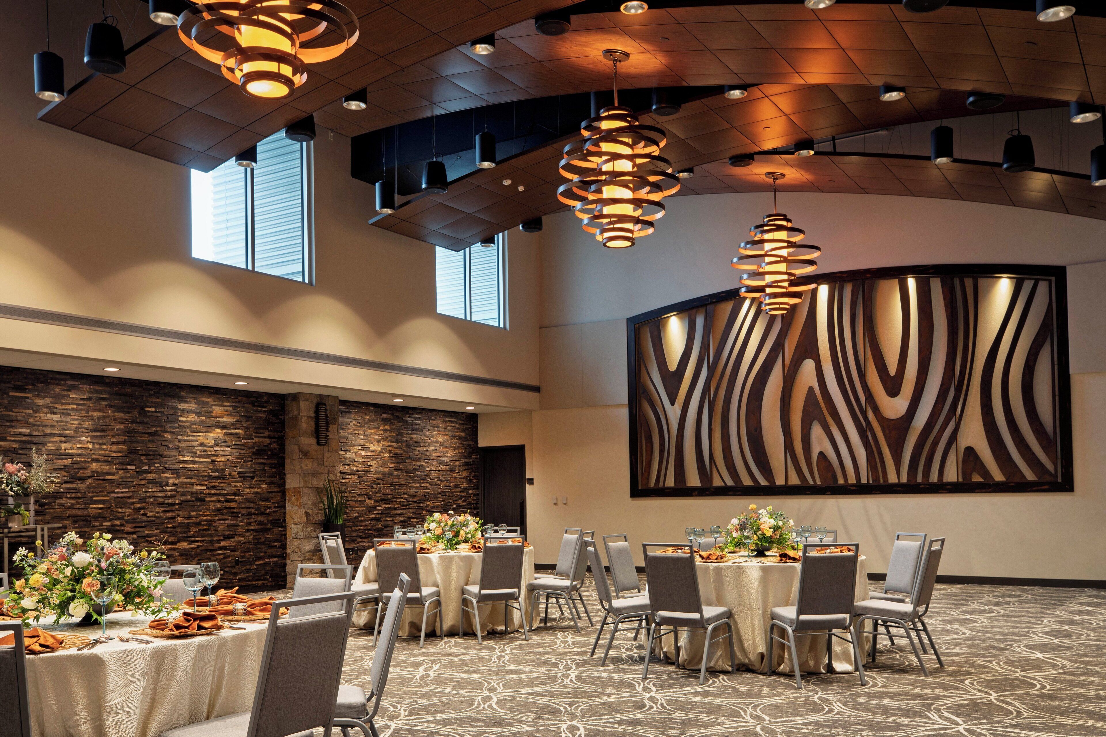 A conference room with round tables, chairs, and modern lighting fixtures.
