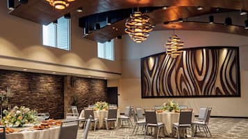 A conference room with round tables, chairs, and modern lighting fixtures.