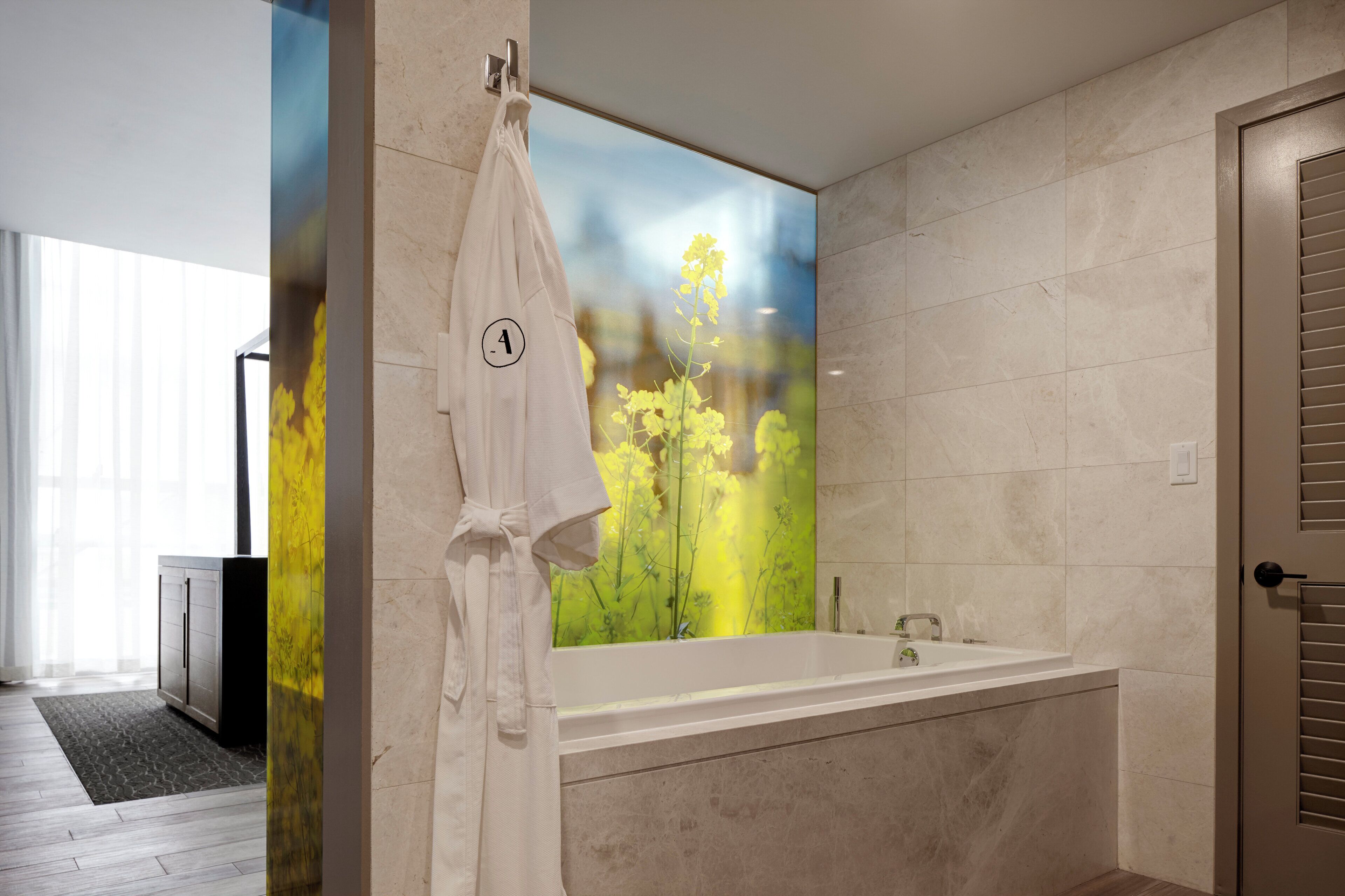 A modern bathroom with a large mirror, a bathtub, and a towel rack.