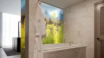 A modern bathroom with a large mirror, a bathtub, and a towel rack.