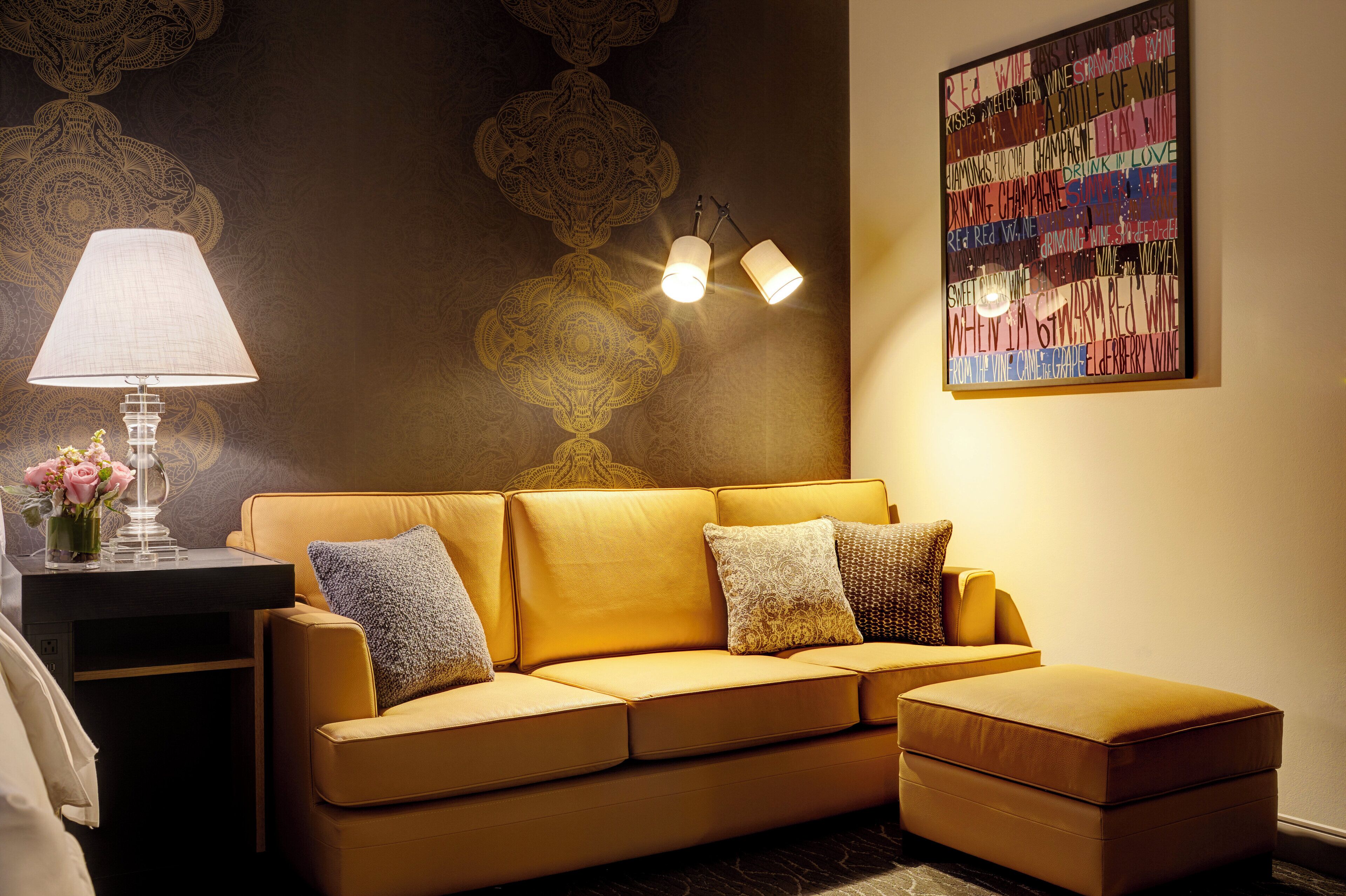 Un salon moderne avec un canapé, une lampe et un élément décoratif mural.