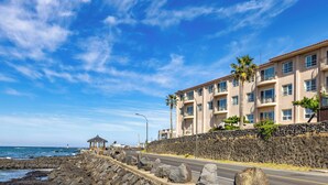 A coastal hotel with a stone wall, a gazebo, and a view of the ocean. - Kensington Resort Jeju Hanlim (Jeju City)
