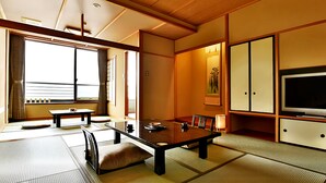 Une pièce de style japonais traditionnel, avec un sol recouvert de tatamis, une table basse et des portes coulissantes.