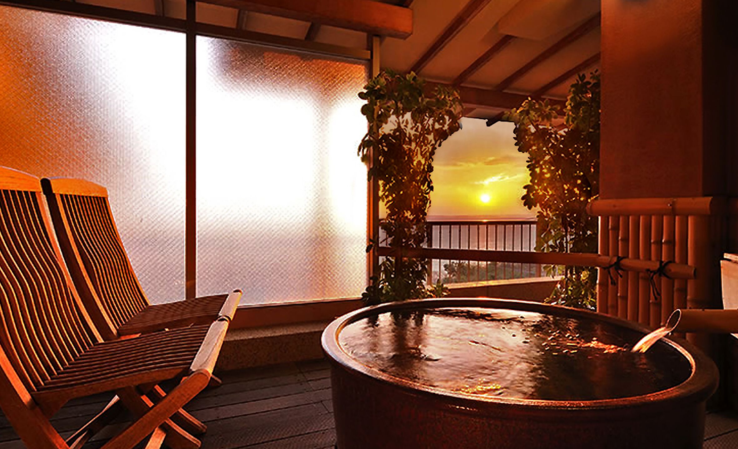 Une terrasse en bois avec un jacuzzi, une chaise et une vue sur le coucher de soleil, encadrée par une arche en bambou.