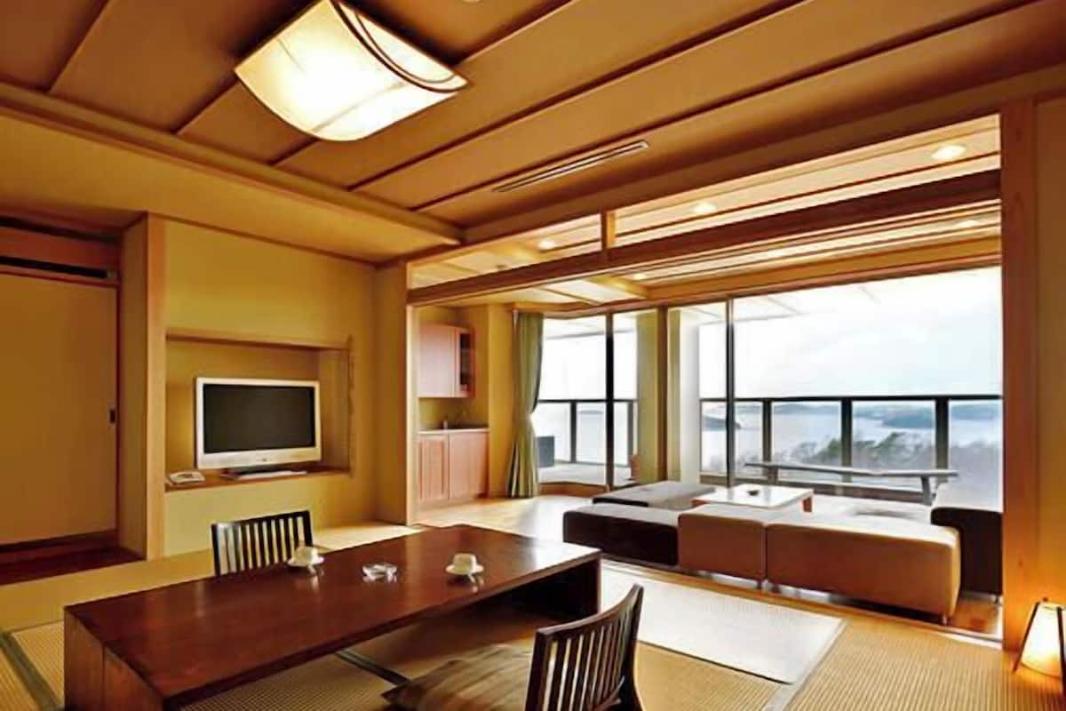 Ett modernt hotellrum med en matplats, en tv och stora fönster med utsikt.