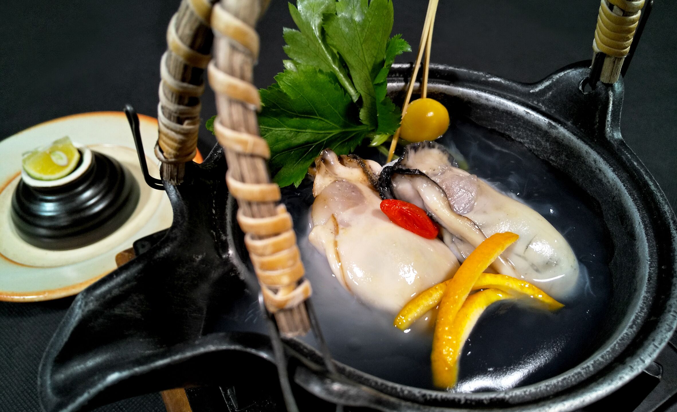 Una olla caliente con diversos ingredientes como carne, verduras y hierbas.