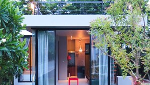 Una casa moderna con amplios ventanales y una silla roja en el centro.