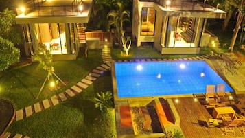 Una piscina al aire libre, sillones reclinables de piscina