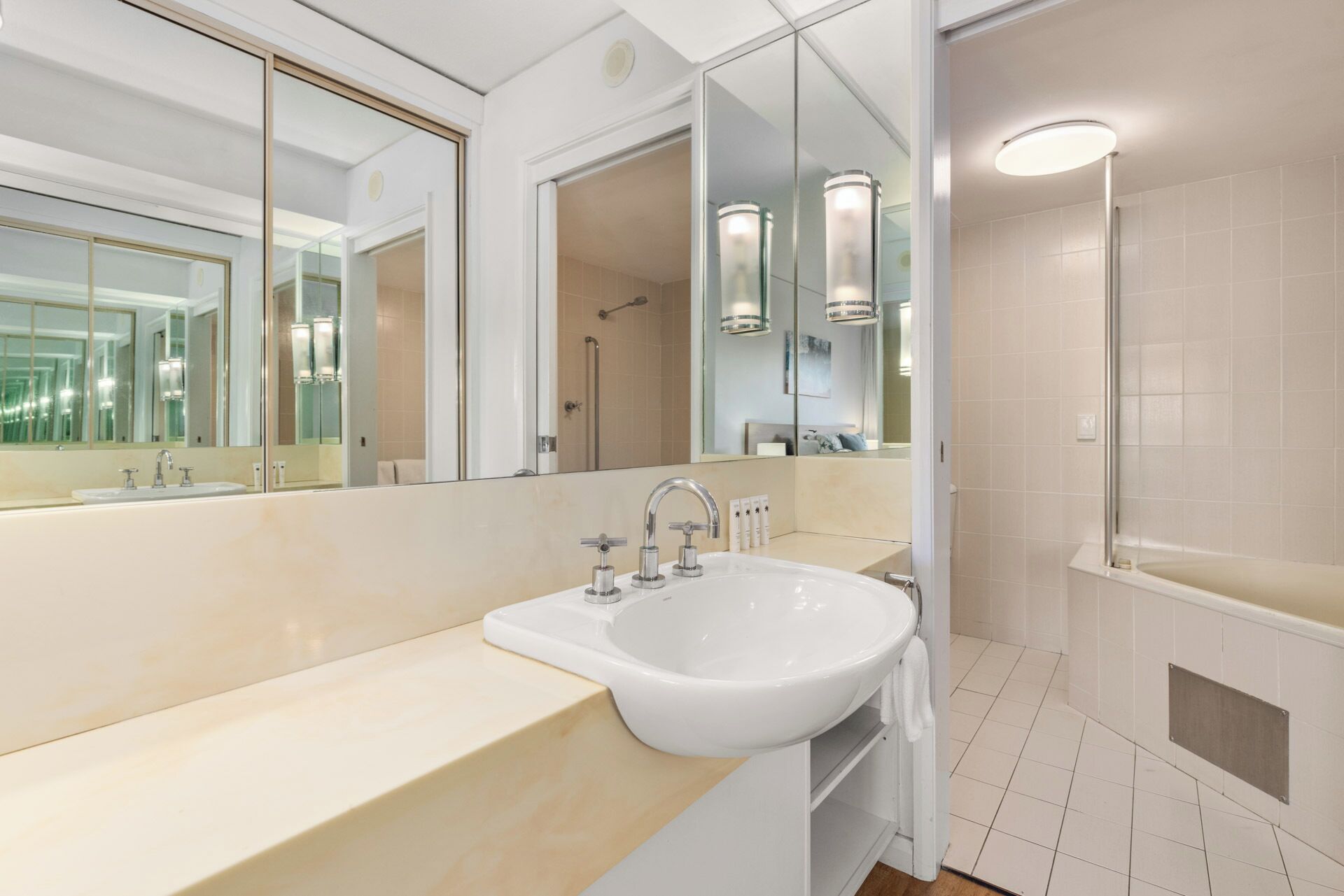 Un baño moderno con un espejo grande, un lavabo y una zona de ducha.