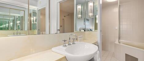 Un baño moderno con un espejo grande, un lavabo y una zona de ducha.