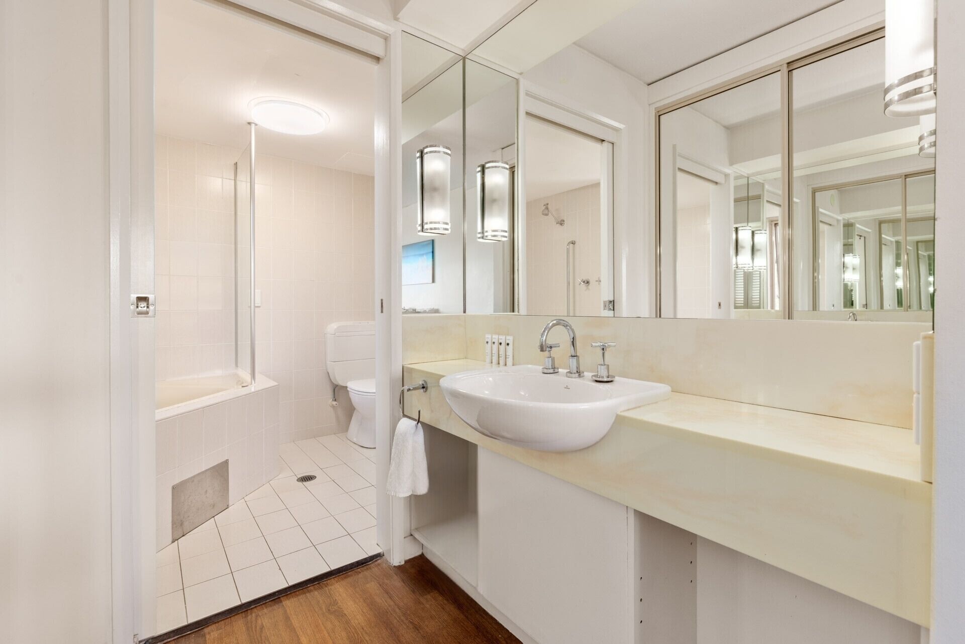 Un baño moderno con un lavamanos blanco, un inodoro y una ducha.