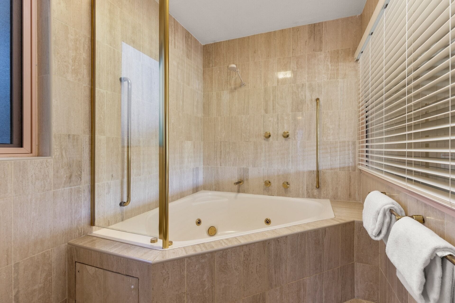 A modern bathroom with a freestanding bathtub, a glass shower enclosure, and a towel rack.