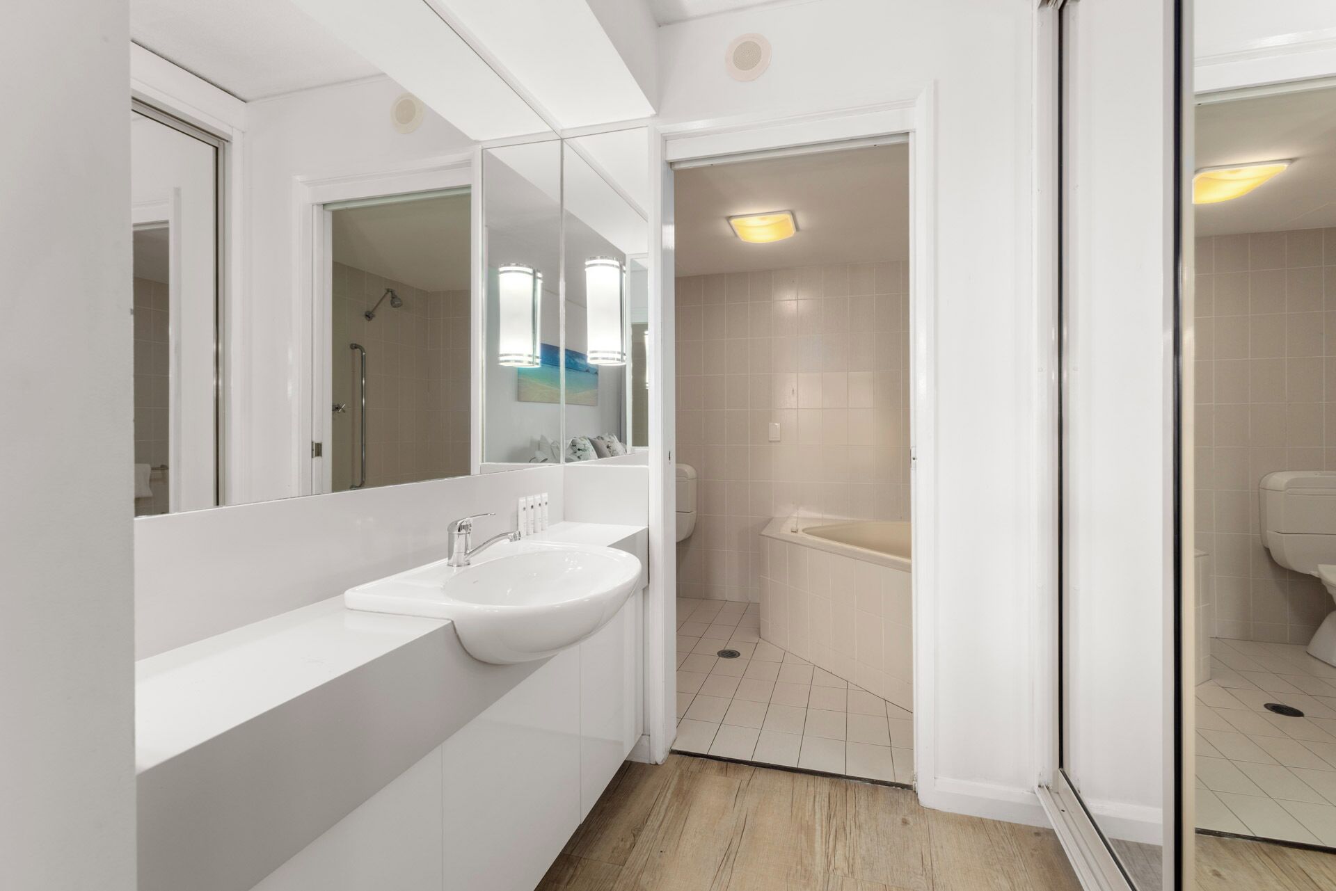 A modern bathroom with a double sink, a large mirror, and a walk-in shower.