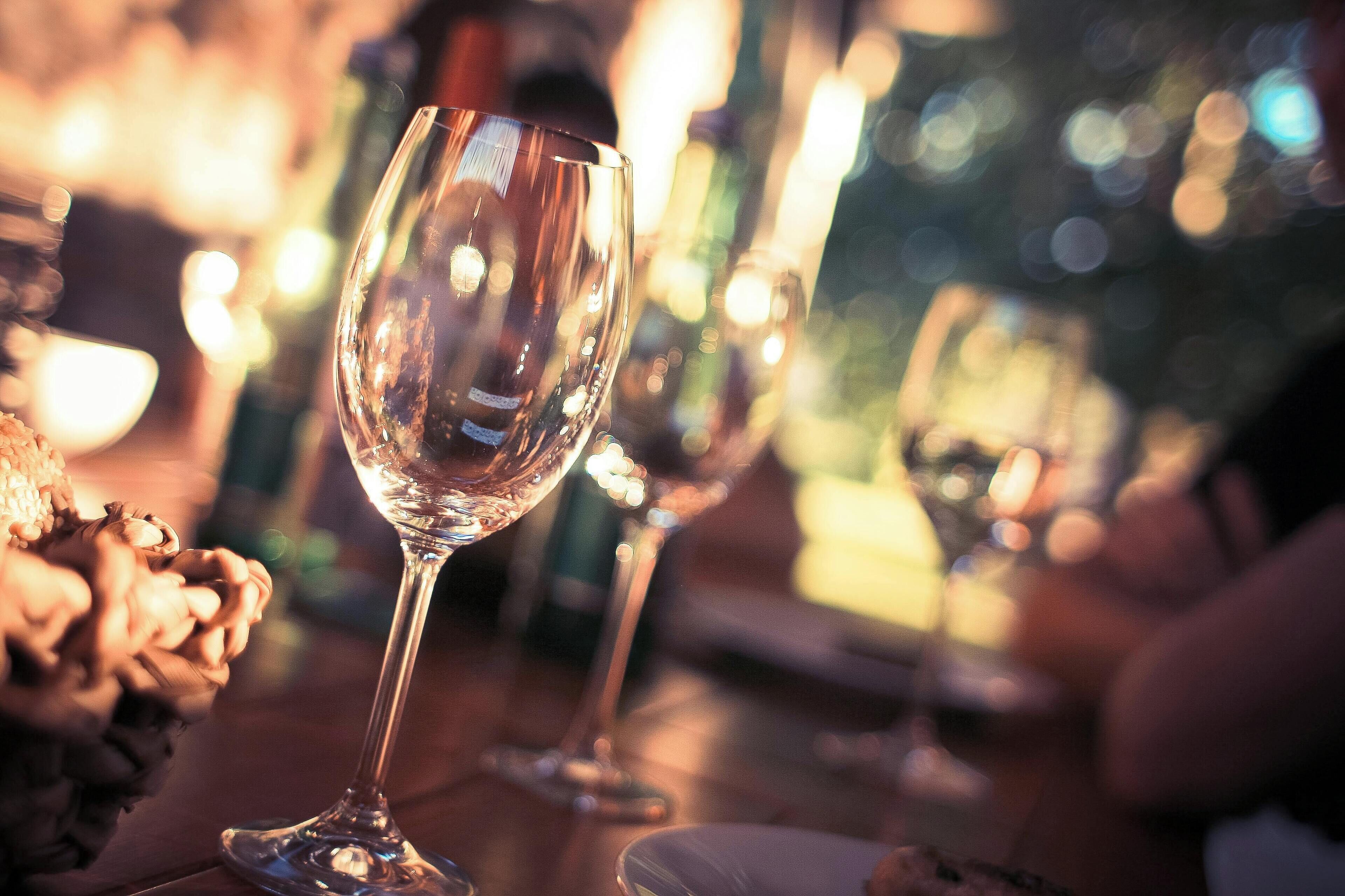 Una mesa con copas y botellas de vino, evocando un ambiente para comer.
