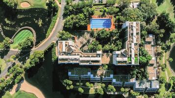 Stunning hotel complex with interconnected buildings, a large pool, and lush green surroundings.