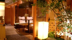 A cozy indoor dining area with a table and chairs, a lamp, and a potted plant.