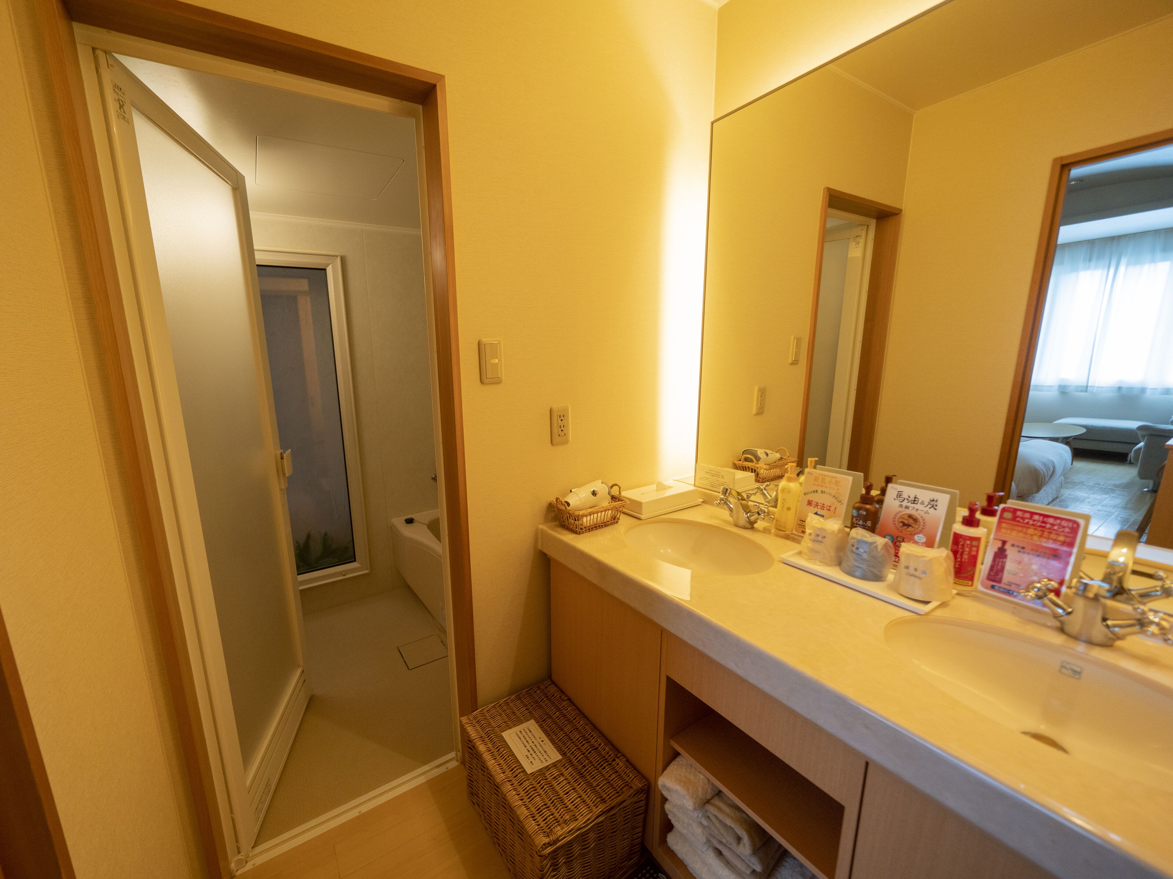 Een hotelbadkamer met een wastafel, spiegel en toiletartikelen.