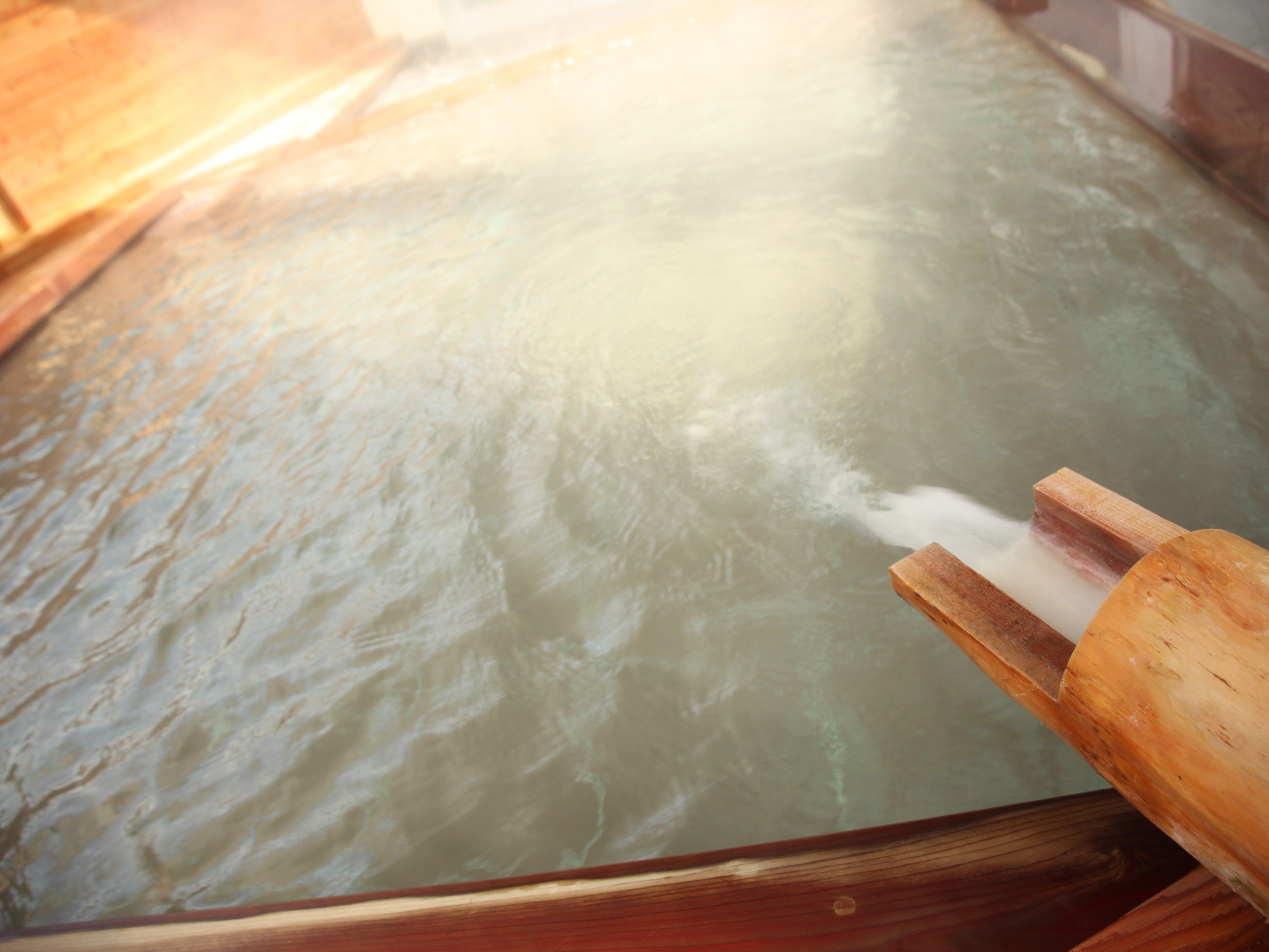 A wooden tub filled with water, likely for a hot tub or spa.