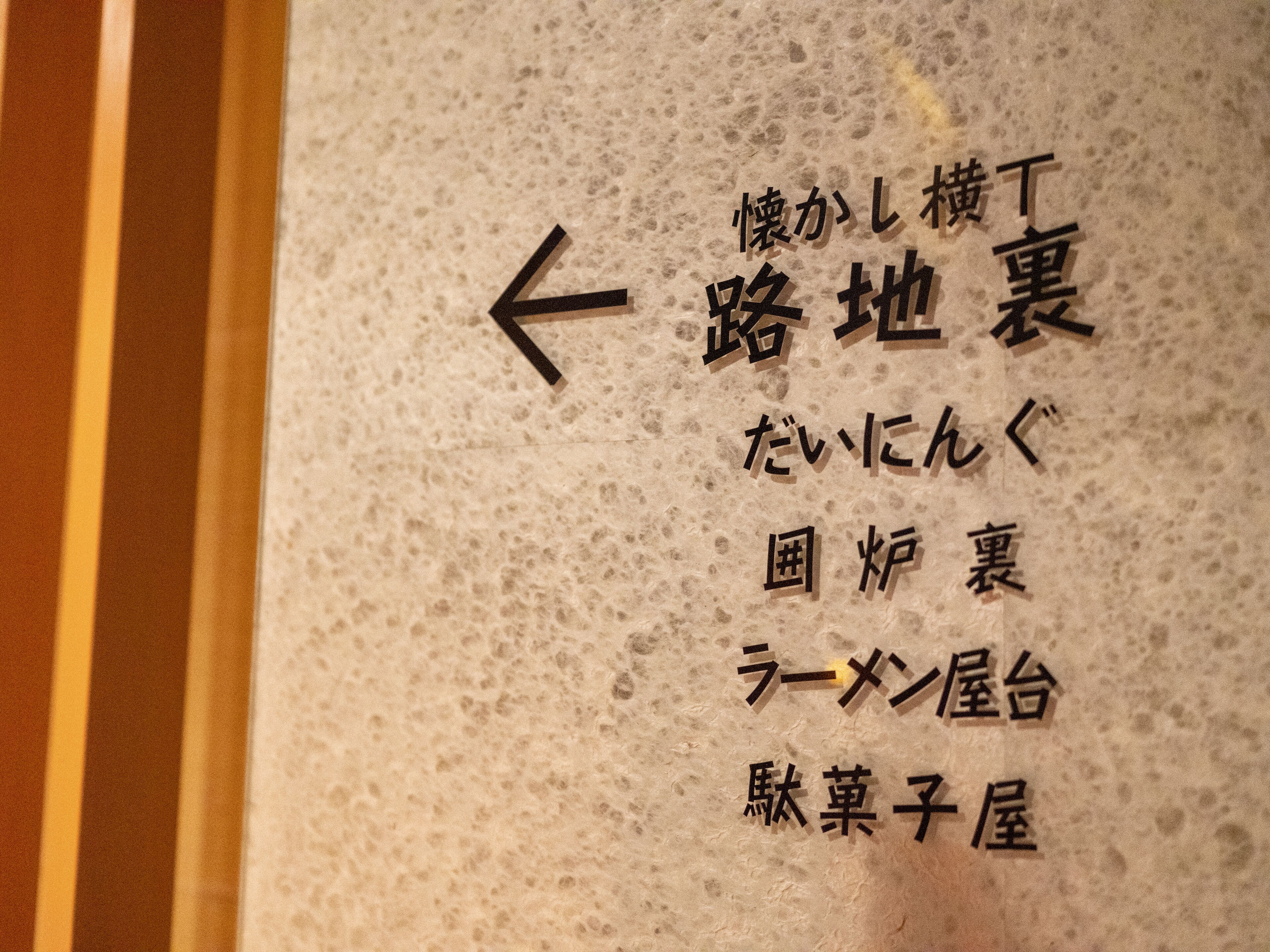 A sign with Japanese text indicating directions to various locations.
