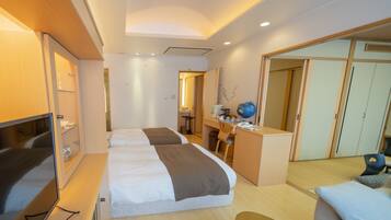 A hotel room with a bed, desk, and wardrobe.