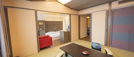 Una habitación de hotel con una cama, un escritorio, una silla, un sofá rojo y un armario.