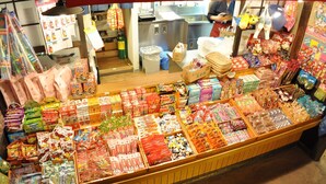 A brightly lit convenience store with various packaged goods and snacks displayed on shelves and counters.