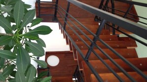 A wooden staircase with black railings leading to an upper floor. - Villa Tranquil (Kandy)