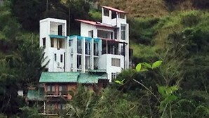A multi-story building with a green roof, surrounded by dense vegetation. - Villa Tranquil (Kandy)