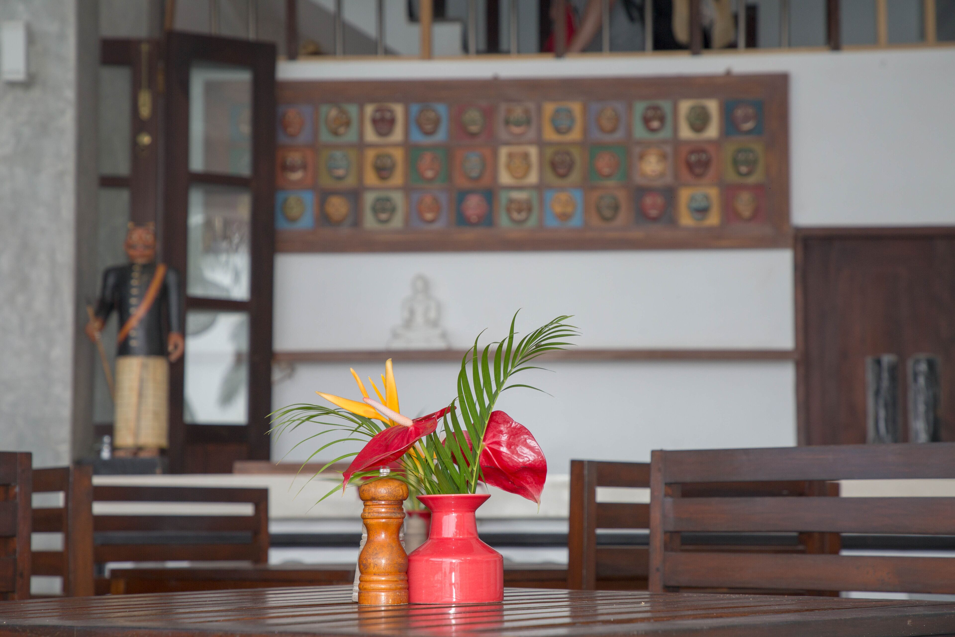 A dining table with two vases, one red and one brown, and a wooden chair.