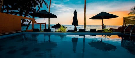 Piscine extérieure, parasols de plage, chaises longues