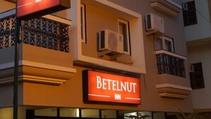 En byggnad som tillhör Betelnut Inn, med flera balkonger och luftkonditioneringsanläggningar.