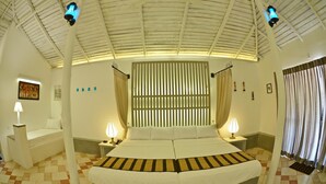 A room with a large bed, two bedside tables, a nightstand, a wall-mounted lamp, and a ceiling fan. - Rangiri Dambulla Resort (Dambulla)