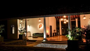 A well-lit entrance with a covered patio, a green sofa, and a decorative leaf wall. - Rangiri Dambulla Resort (Dambulla)