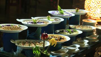 A buffet table with various dishes and a decorative centerpiece.