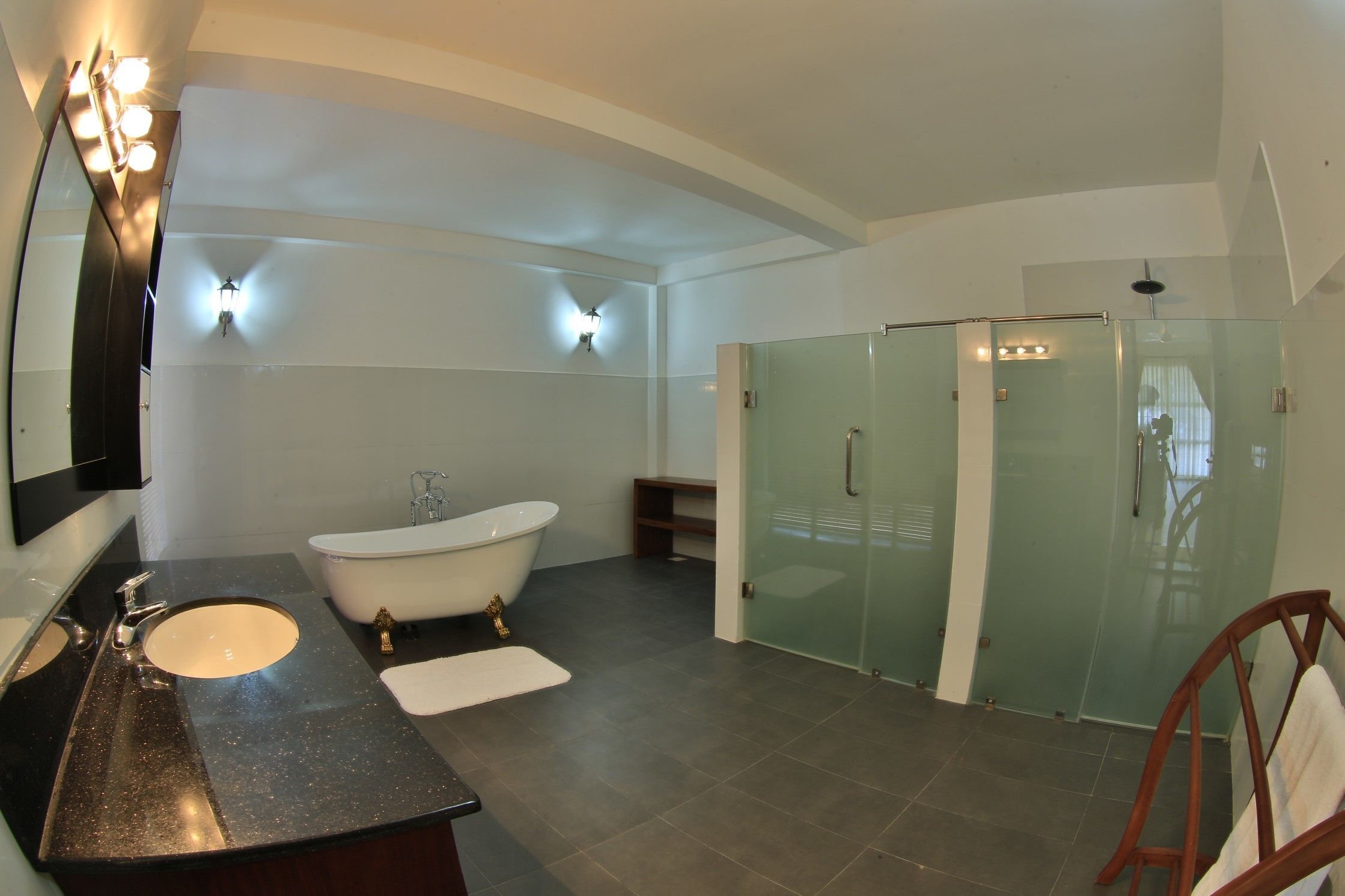 A modern bathroom with a freestanding bathtub, a glass-enclosed shower, and a vanity with a sink and mirror.